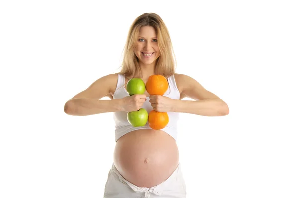 リンゴとオレンジから作られたフィットネス ダンベルに関与する妊娠中の女性 — ストック写真