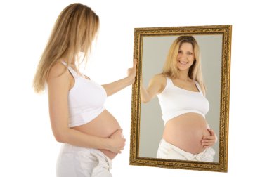 Pregnant woman looks in the mirror isolated on a white clipart