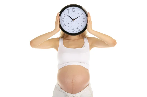 Hamile kadın yuvarlak bir saat yüzü tutar — Stok fotoğraf