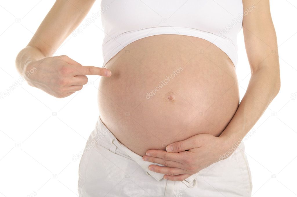 Pregnant woman shows her belly isolated on white