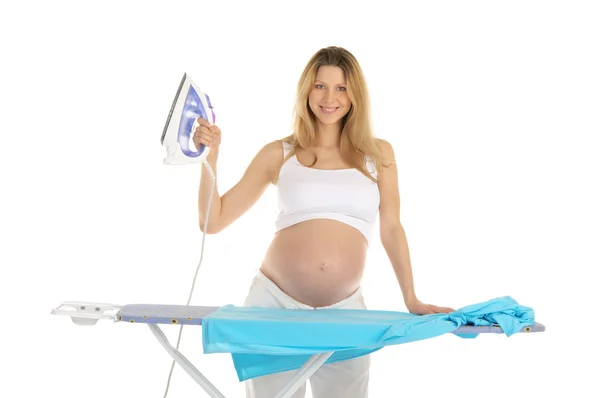 Těhotná žena v bílém obleku s žehličkou — Stock fotografie