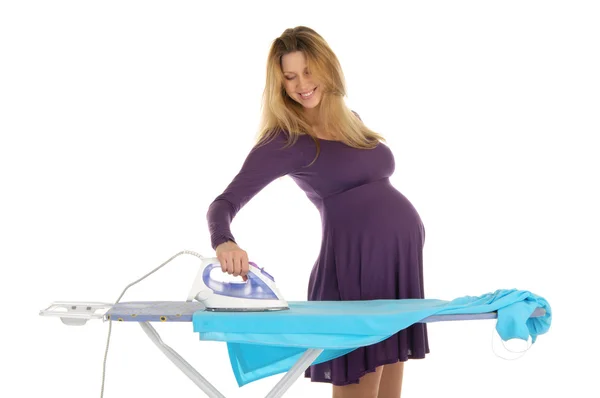 Gravid kvinna i en lila klänning med ett strykjärn — Stockfoto