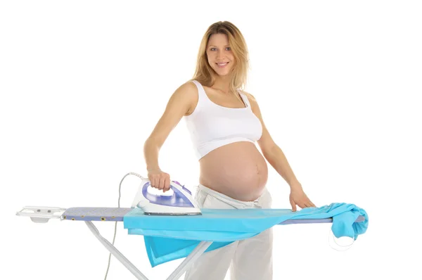 Mulher grávida em um terno branco com um ferro — Fotografia de Stock