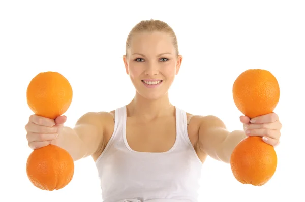 Vrouw die zich bezighouden met fitness halters van sinaasappelen — Stockfoto