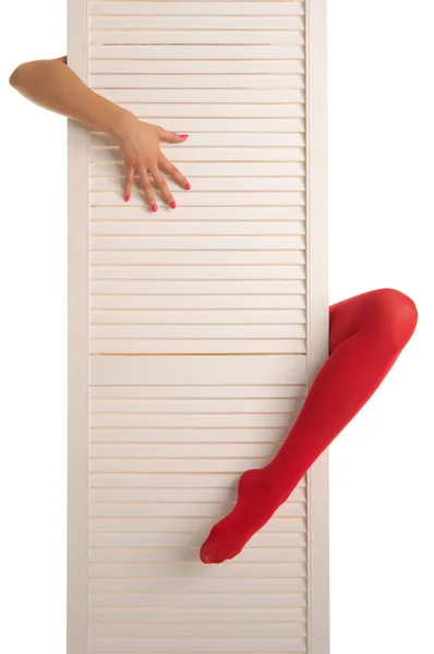 Kvinnliga fötter i röda strumpor, händer och dörr — Stockfoto