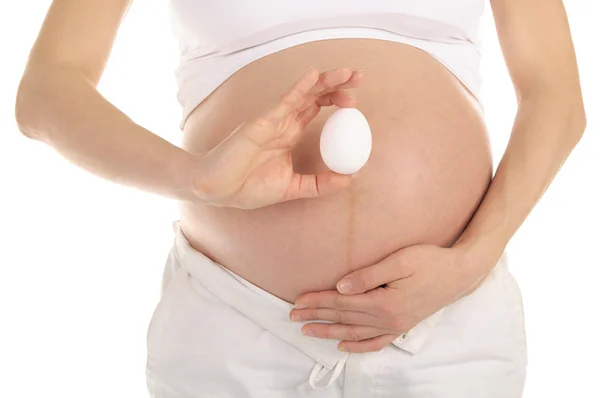 Kobieta w ciąży trzymając jajko — Zdjęcie stockowe