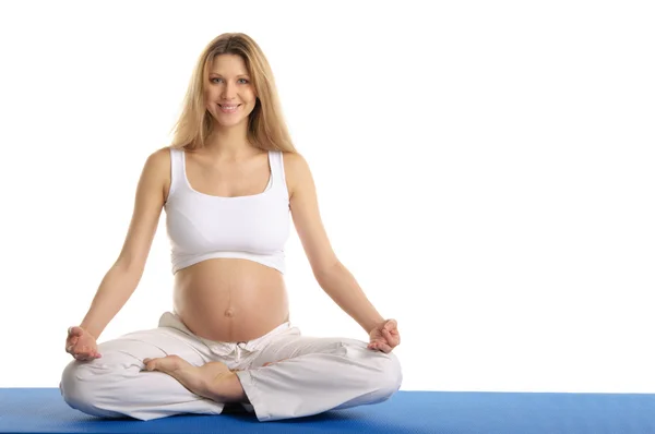 Hamile kadın oturup yoga uygulamak — Stok fotoğraf