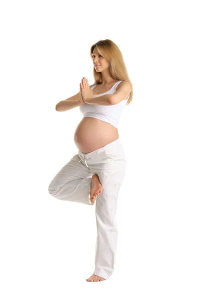 Mulher grávida praticando ioga, de pé Imagem De Stock
