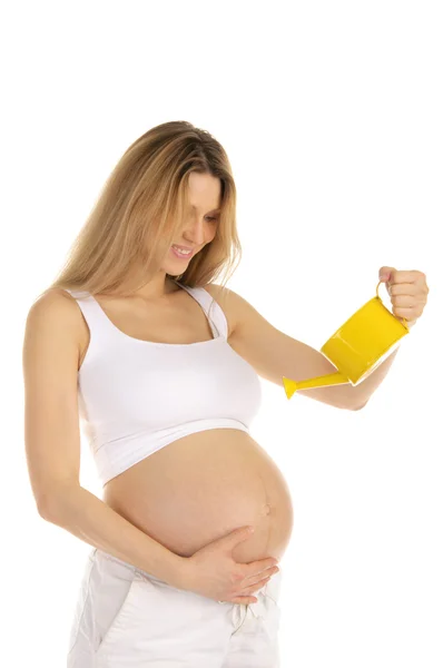 Беременная женщина поливает живот — стоковое фото