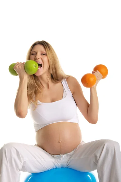 Donna incinta morde frutta manubri — Foto Stock