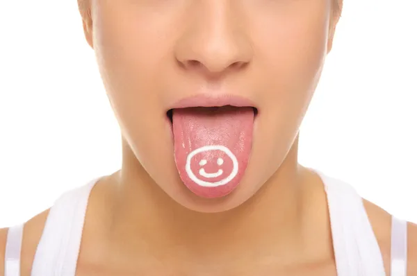 Женский язык с нарисованным счастливым лицом — стоковое фото