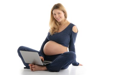 Pregnant woman with a laptop sitting on the floor clipart