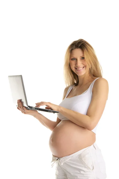 Счастливая беременная женщина с ноутбуком — стоковое фото
