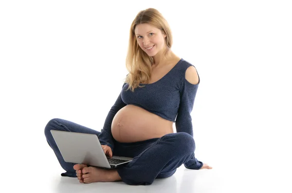 Mulher grávida com um laptop sentado no chão — Fotografia de Stock