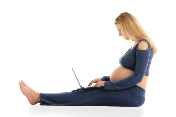 Έγκυος γυναίκα με ένα φορητό υπολογιστή που κάθεται στο πάτωμα — Φωτογραφία Αρχείου