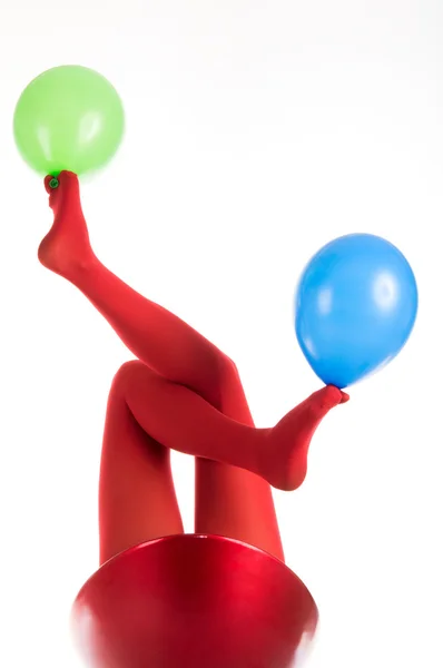 Pés femininos em meias vermelhas com balões — Fotografia de Stock
