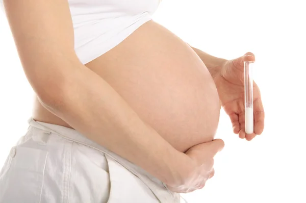 Беременная женщина держит пробирку со спермой — стоковое фото