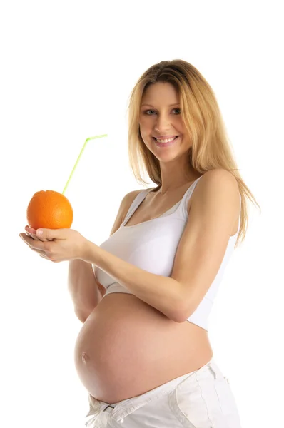 Pregnant woman holding orange with straw — Stock Photo, Image