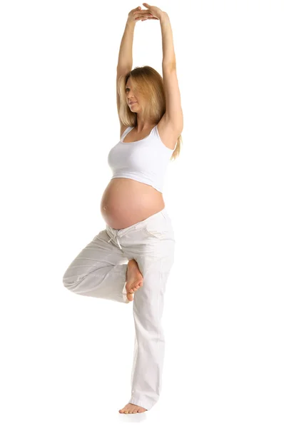 Беременная женщина, практикующая йогу, стоящая — стоковое фото