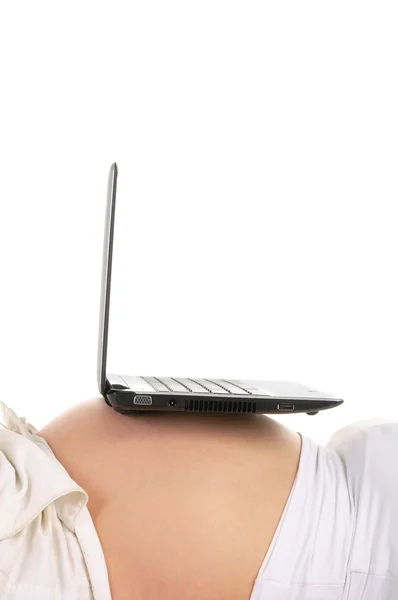 Ноутбук на животе беременной женщины — стоковое фото