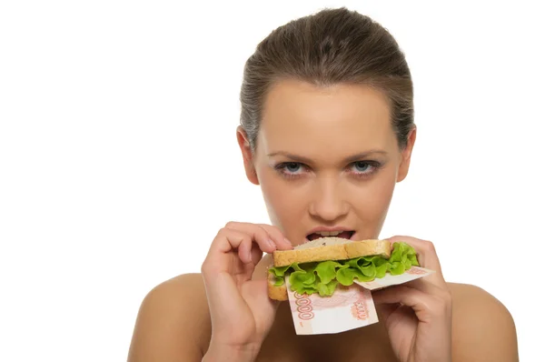 Woman biting a sandwich out of money and lettuce — Stock Photo, Image