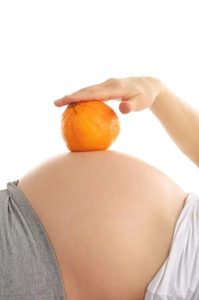 Abdómen de mulher grávida com laranja — Fotografia de Stock