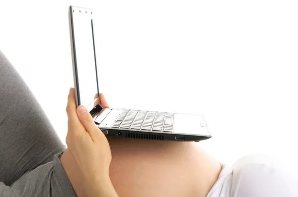 Ноутбук на животе беременной женщины — стоковое фото