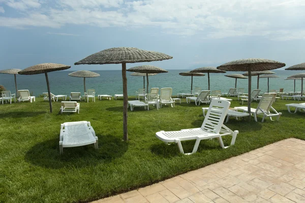 Ligbedden en parasols op gras in het hotelgebied — Stockfoto