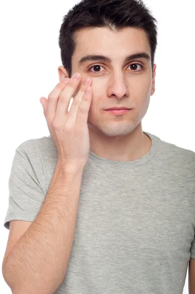 Hombre joven aplicando crema para los ojos —  Fotos de Stock