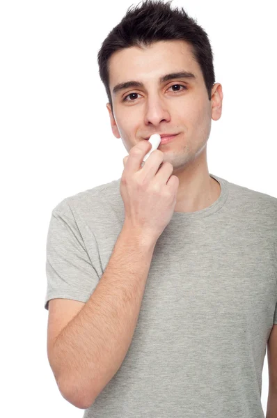 Hombre joven aplicando bálsamo labial — Foto de Stock