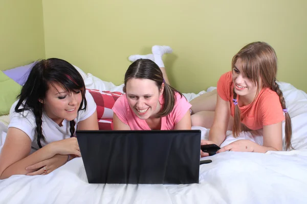 stock image Girls on bed using laptop