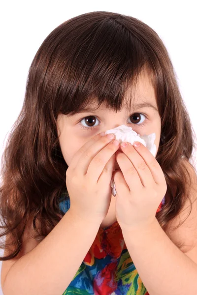 Маленькая девочка вытирает нос салфеткой — стоковое фото