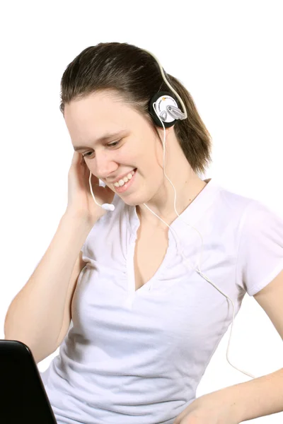 魅力的な若い女性はラップトップ コンピューターでの技術サポートや顧客サービスのためのヘッドセットに笑みを浮かべて — ストック写真