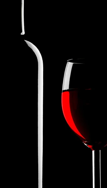 Винное стекло и бутылка на черном — стоковое фото