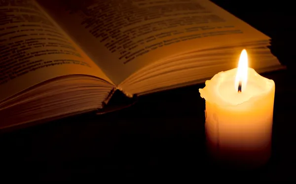 Libro a la luz de las velas —  Fotos de Stock