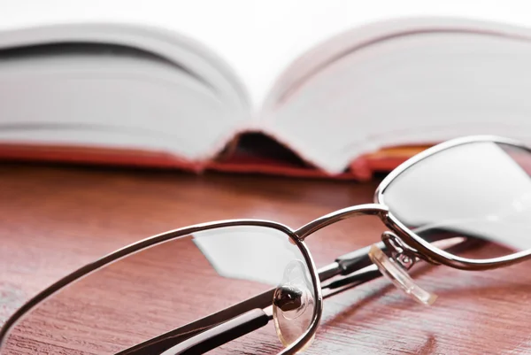 Szemüveg és nyitott könyv — Stock Fotó