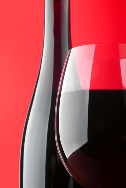 Foto Una Copa Vino Con Una Botella Sobre Fondo Rojo —  Fotos de Stock