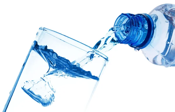 A água pura vaza-se de uma garrafa em um copo — Fotografia de Stock