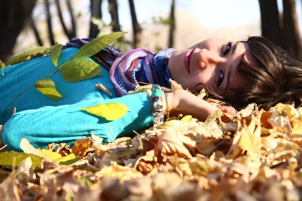 Young girl lying in the autumn fall leaves Royalty Free Stock Photos