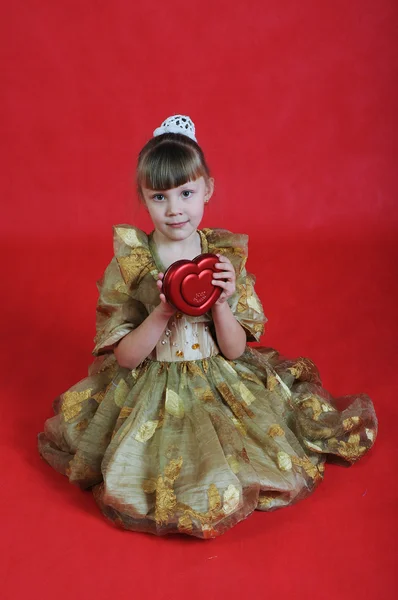 Viehättävä Pieni Tyttö Istuu Lattialla Punaisella Sydämellä Eristetty Valkoisella Taustalla — kuvapankkivalokuva