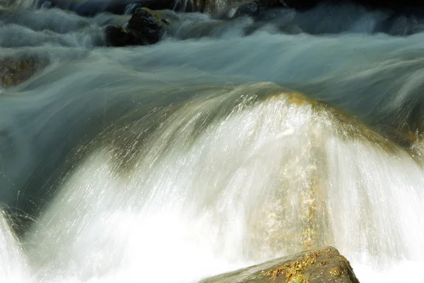 Un río de montaña con arroyo cayendo en él por la mañana —  Fotos de Stock