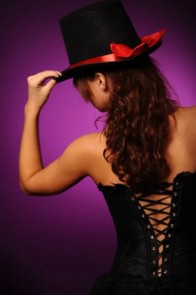 Mulher de beleza em espartilho preto e chapéu de seda — Fotografia de Stock