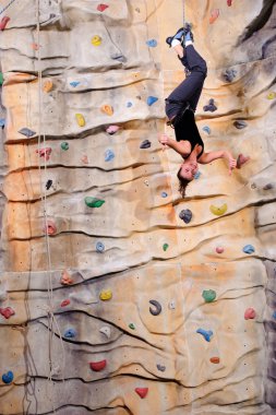 Young woman on rock wall clipart