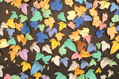 Paper leafes made by childrens on the blackboard clipart