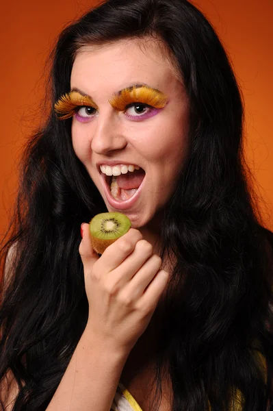 Beleza jovem mulher comer kiwi — Fotografia de Stock