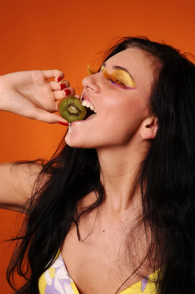 Beauty young woman eat kiwi — Stock Photo, Image