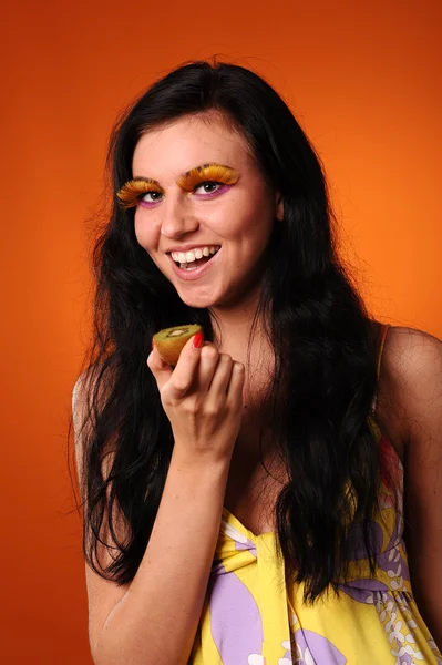 Mujer joven quiere comer kiwi —  Fotos de Stock