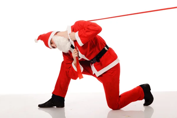 Санта-Клаус тянет красную ленточку — стоковое фото