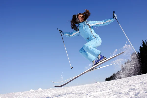 Прыжок счастливой молодой лыжницы — стоковое фото