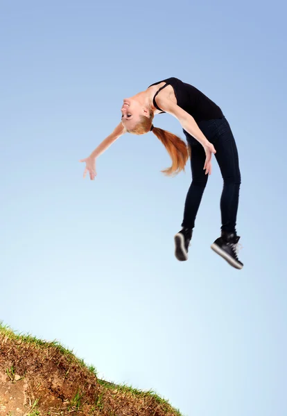 Agile flippige junge Frau springt — Stockfoto